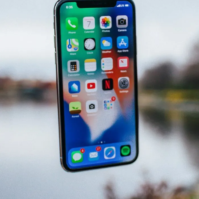 Smartphone před rozmazaným jezerem